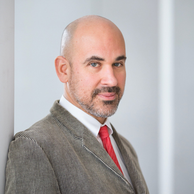 Image of Carter in a grey suit and red tie