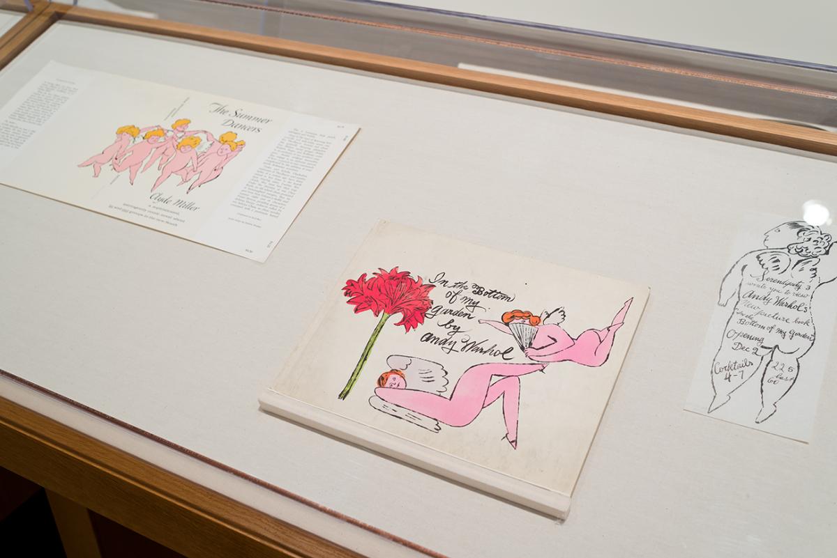 Three illustrations of angels in a display case